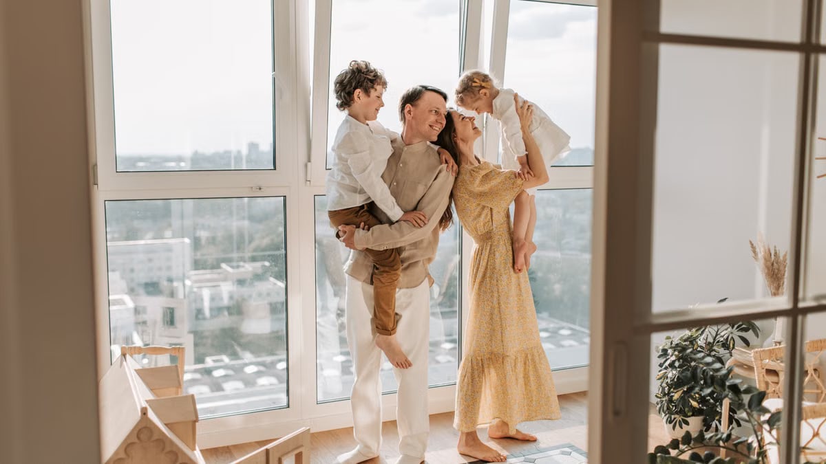 Happy family with children enjoying time together in a sunlit modern apartment.